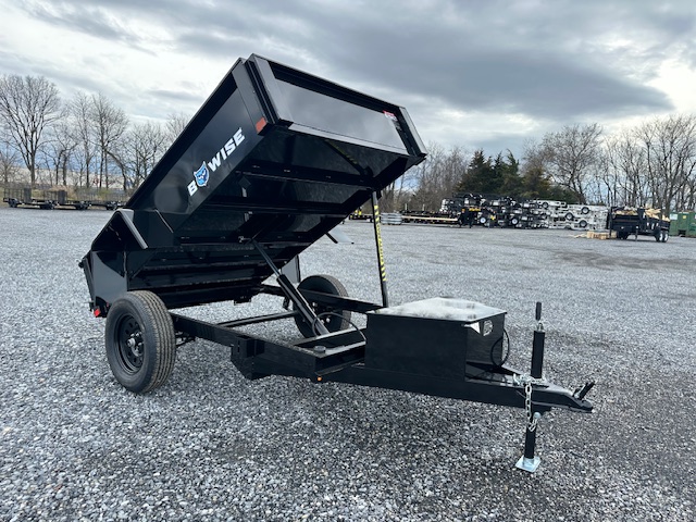 a bo wise dump trailer is parked in a gravel lot