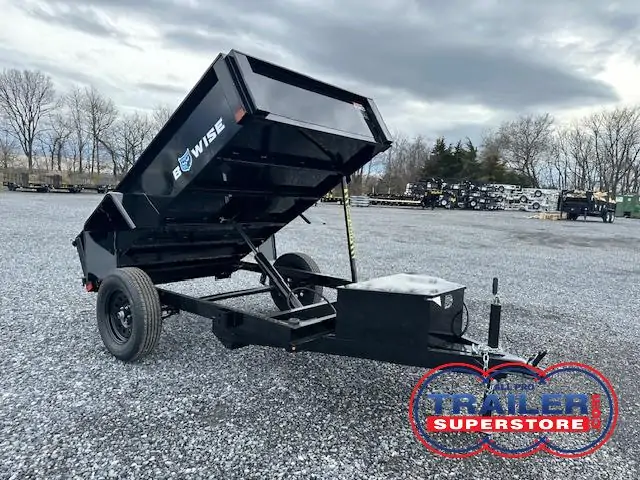 a bo wise dump trailer is parked in a gravel lot