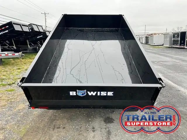 a dump trailer is sitting on the side of the road .
