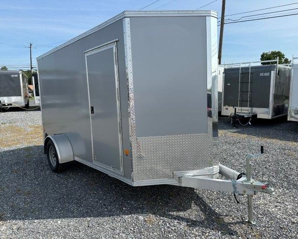 a gray trailer parked in a gravel lot