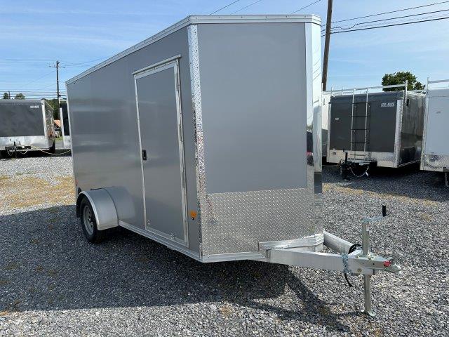 a gray trailer parked in a gravel lot
