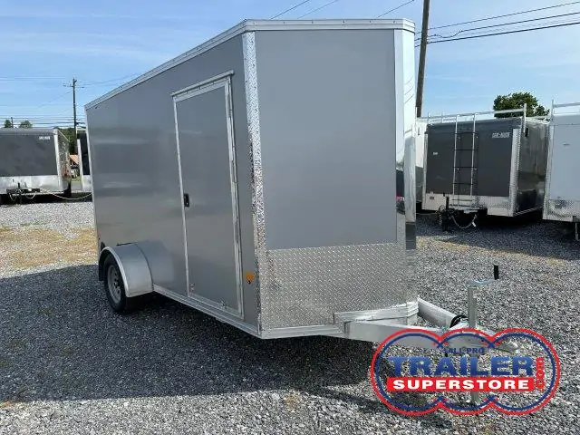 a gray trailer parked in a gravel lot