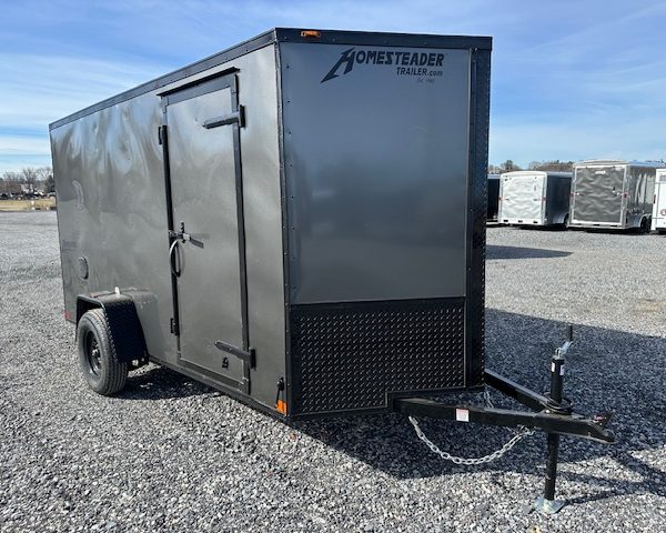 a homesteader trailer is parked in a gravel lot