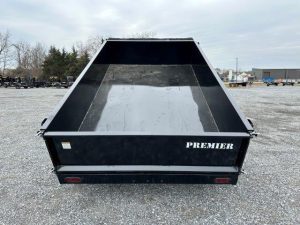 a dumpster trailer is parked in a gravel lot .