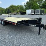a Premier trailer with a wooden deck parked in a gravel lot