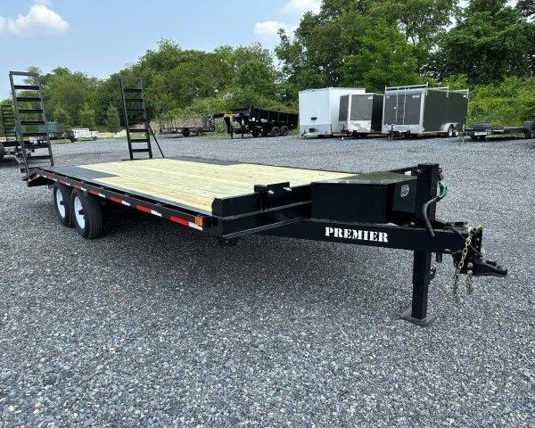 a Premier trailer with a wooden deck parked in a gravel lot