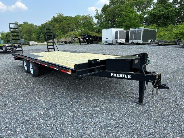 a Premier trailer with a wooden deck parked in a gravel lot