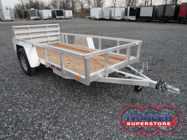 a Sport Haven aluminum trailer with a wooden deck parked in a gravel lot