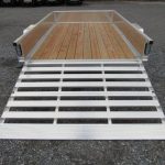 a silver trailer with a wooden deck and a ramp