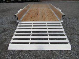a silver trailer with a wooden deck and a ramp