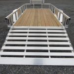 a trailer with a wooden deck and a silver ramp .