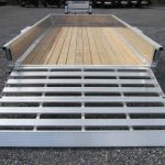 a trailer with a wooden deck and a metal ramp .