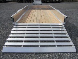 a trailer with a wooden deck and a metal ramp .