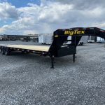 a big tex trailer is parked in a gravel lot