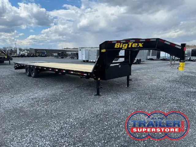 a big tex trailer is parked in a gravel lot