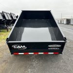 a black dump trailer parked on the side of the road