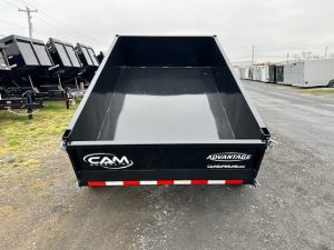 a black dump trailer parked on the side of the road
