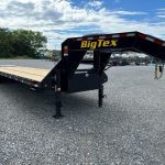 a BigTex flatbed trailer parked in a gravel lot
