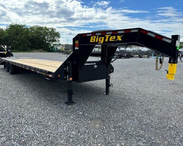 a BigTex flatbed trailer parked in a gravel lot