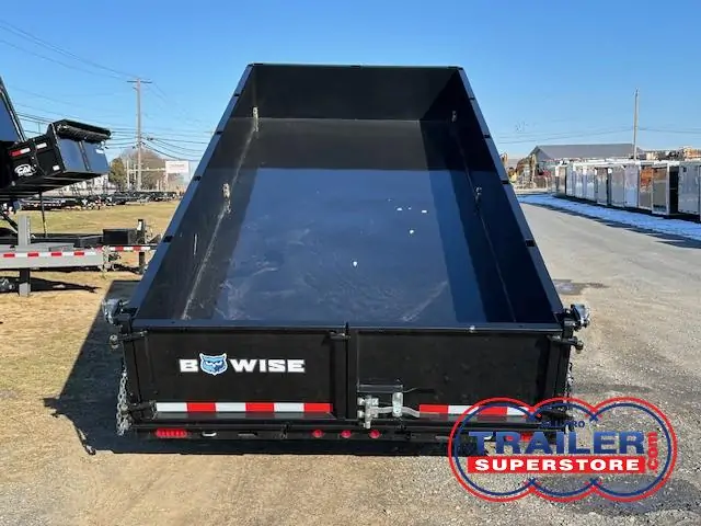 a dump trailer is parked on the side of the road .