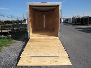 the inside of a Homesteader trailer with the door open and a wooden floor