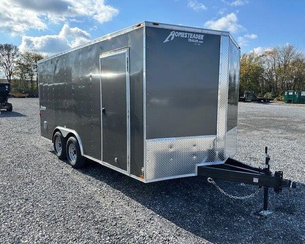 a gray trailer parked in a gravel lot