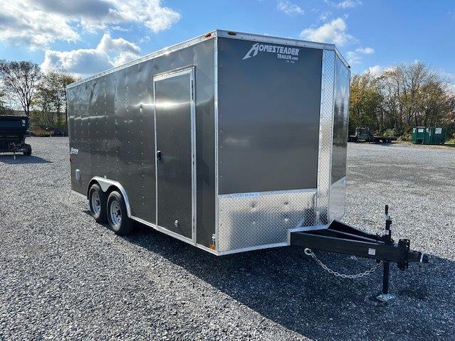 a gray trailer parked in a gravel lot