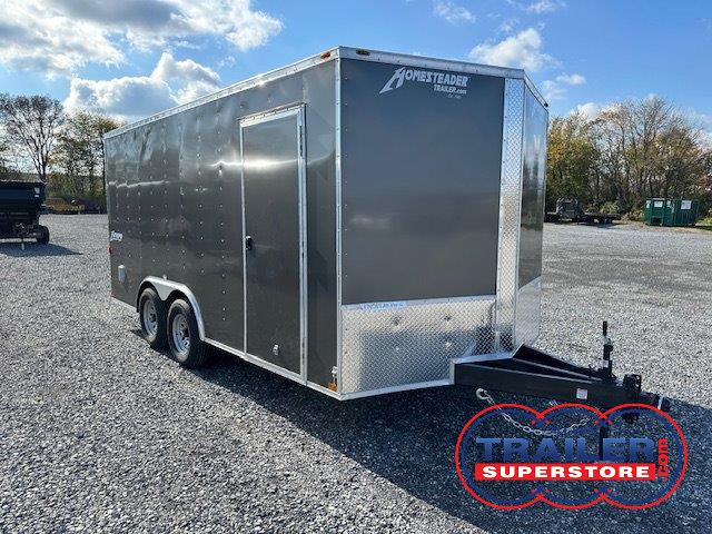 a gray trailer parked in a gravel lot