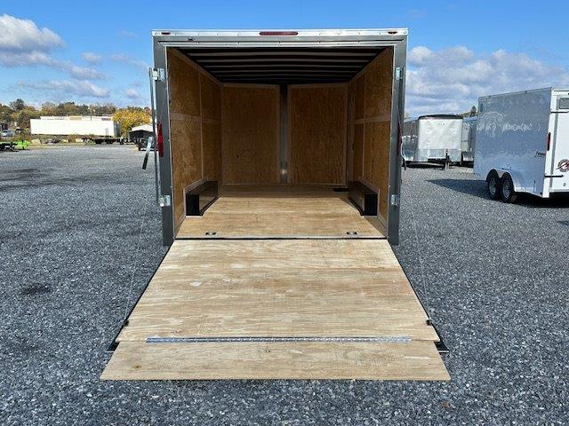 a trailer with the door open is parked in a gravel lot