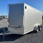 cargo trailer is parked in a gravel lot .