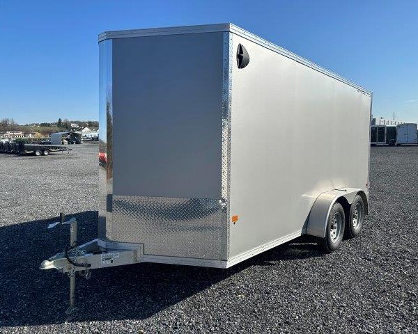 cargo trailer is parked in a gravel lot .