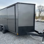 a gray trailer parked in a gravel lot
