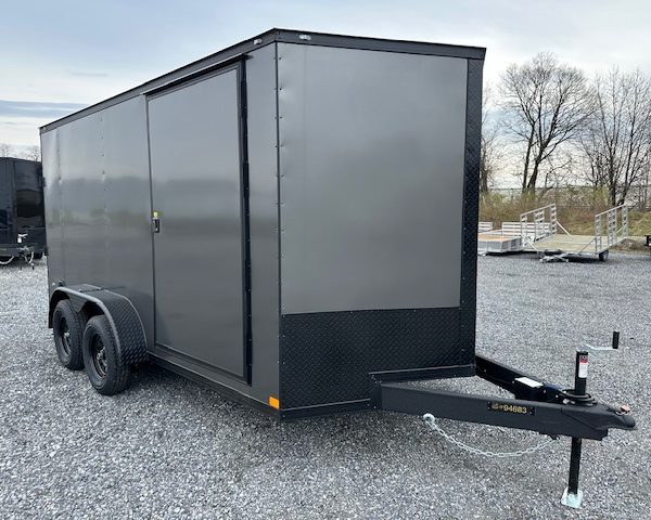 a gray trailer parked in a gravel lot