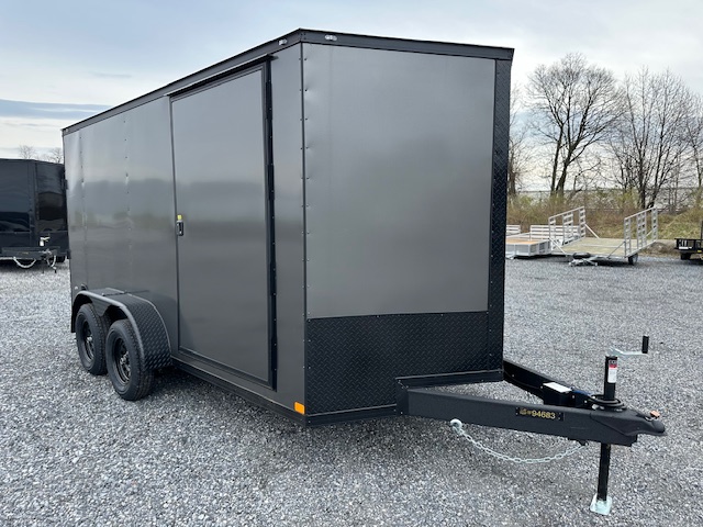 a gray trailer parked in a gravel lot