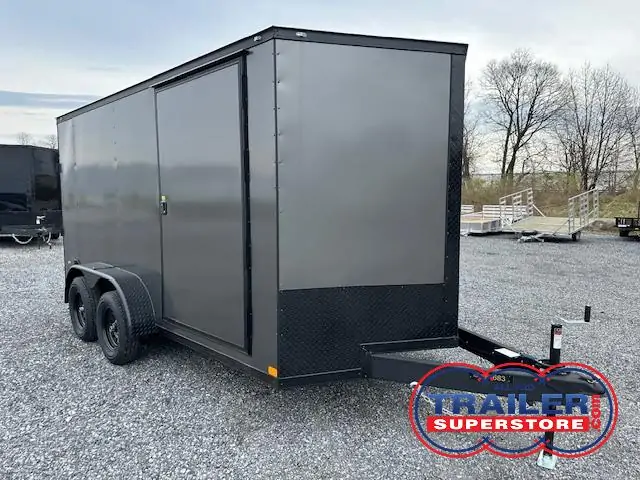 a gray trailer parked in a gravel lot