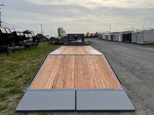 a bwise trailer with a wooden deck is parked on the side of the road .