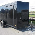 a black trailer parked on the side of the road