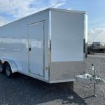 a white trailer parked in a gravel lot