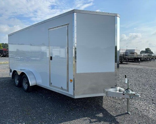a white trailer parked in a gravel lot
