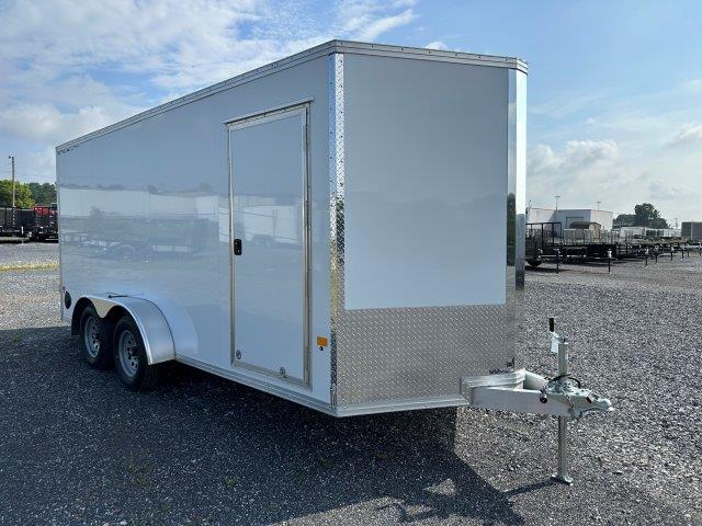 a white trailer parked in a gravel lot