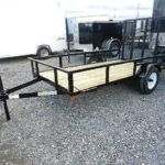 a black Premier utility trailer is parked next to other trailers