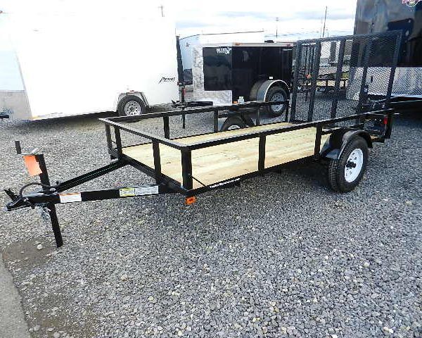 a black Premier utility trailer is parked next to other trailers