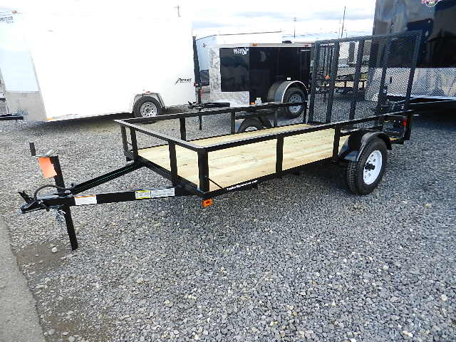 a black Premier utility trailer is parked next to other trailers