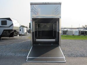 an ATC 8.5x26 trailer with the door open parked in a gravel lot