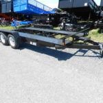 a black Car Mate open rail car hauler is parked on the side of the road