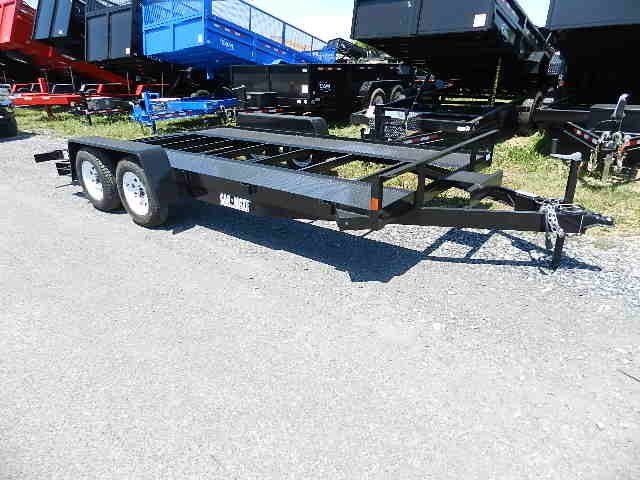 a black Car Mate open rail car hauler is parked on the side of the road