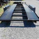 a black trailer parked on a gravel road