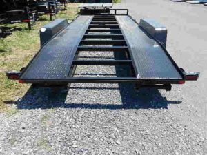 a black trailer parked on a gravel road