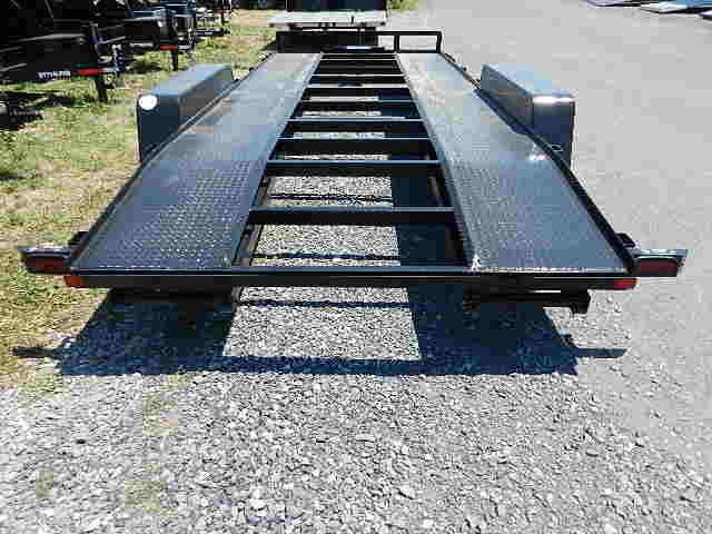 a black trailer parked on a gravel road