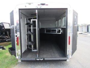 the inside of a homesteader horse trailer with the doors open .